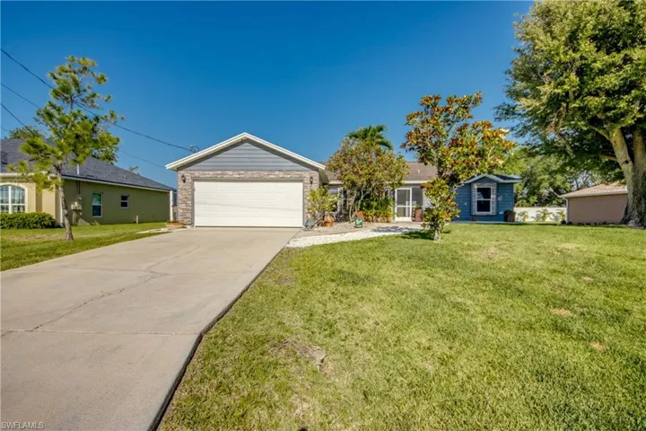 Single story home with concrete driveway, a garage, and a front lawn