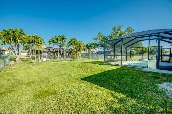 View of yard with an outdoor pool and glass enclosure