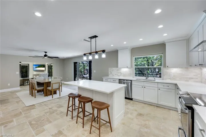 Kitchen features stainless appliances, quartz counter tops and white shaker cabinets.