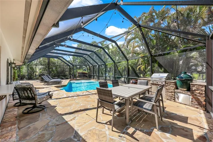Outdoor area features HUGE pool, plenty of room for dining and sunbathing PLUS an outdoor kitchen!