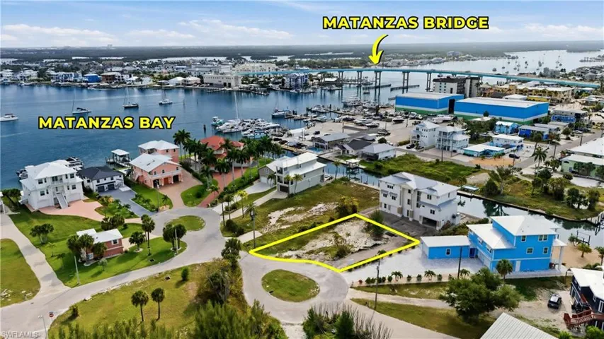 Vacant land parcel situated on a paved street, featuring surrounding residential properties, proximity to a canal, and access to Matanzas Bay via waterways - Virtually Edited Image