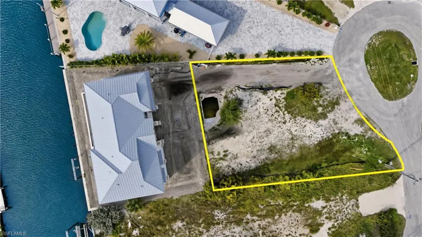 Aerial view of lot surrounded by bay- virtually enhanced
