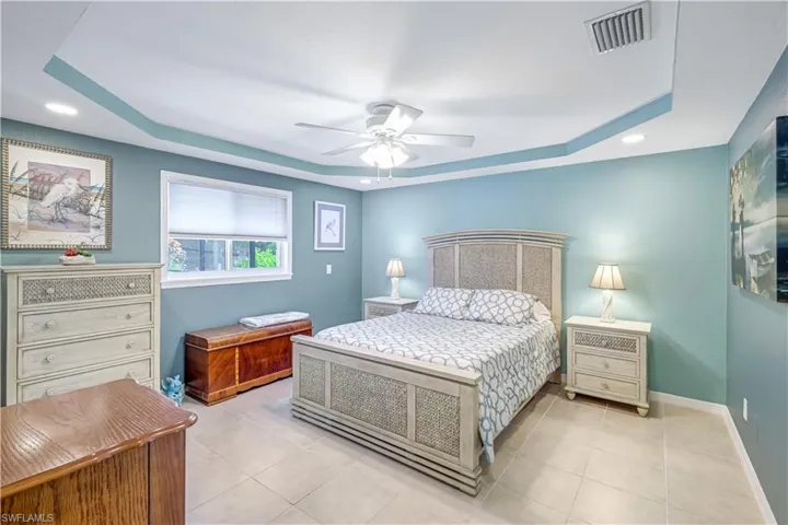 Large primary bedroom with tray ceiling.