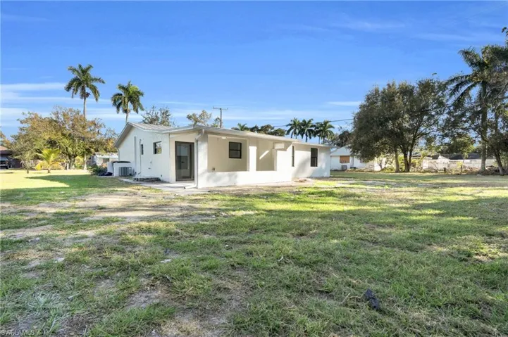 Rear view of house featuring a yard, stucco siding, and a patio area