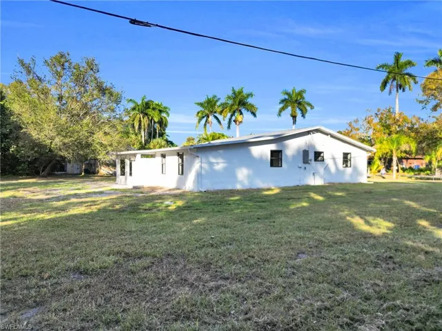 View of side of home with stucco siding and a lawn