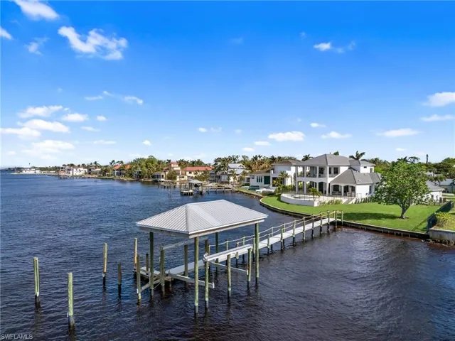 View of dock featuring a lawn and a water view
