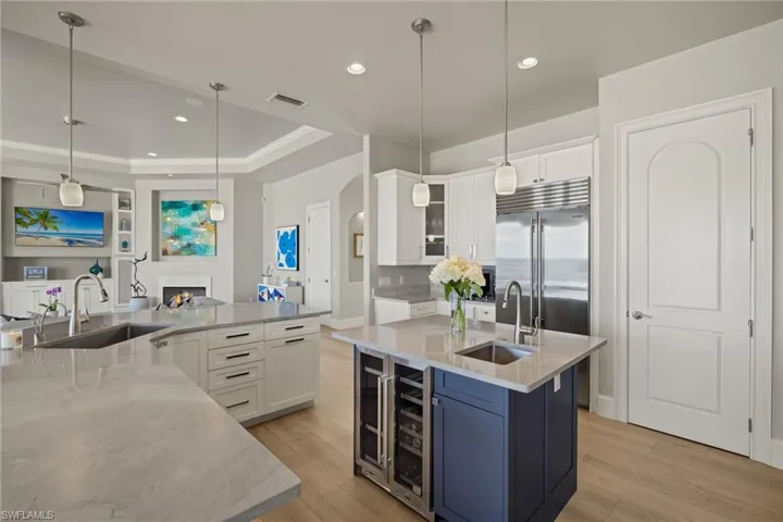 Kitchen with white cabinetry, sink, and hanging light fixtures