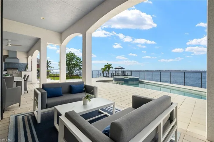 View of patio / terrace featuring area for grilling, an outdoor living space, a water view, and a pool with hot tub