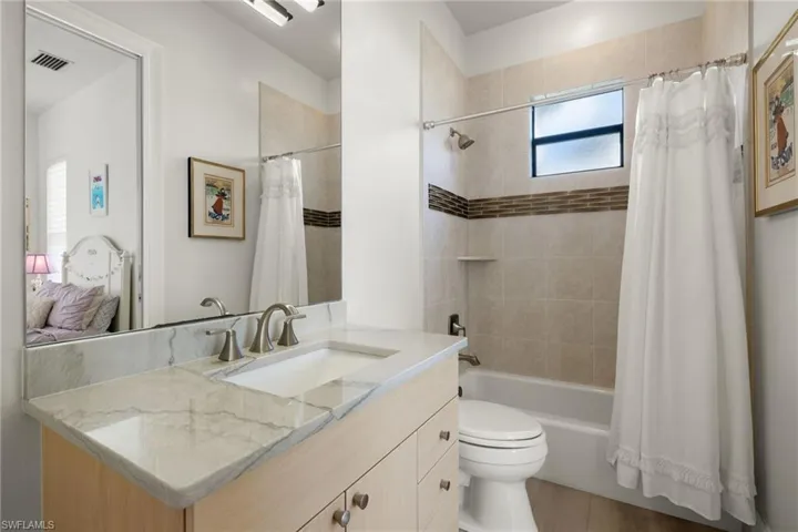 Full bathroom with hardwood / wood-style flooring, vanity, toilet, and shower / tub combo