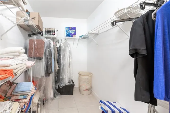 Walk-in closet featuring white wire shelving and hanging rods