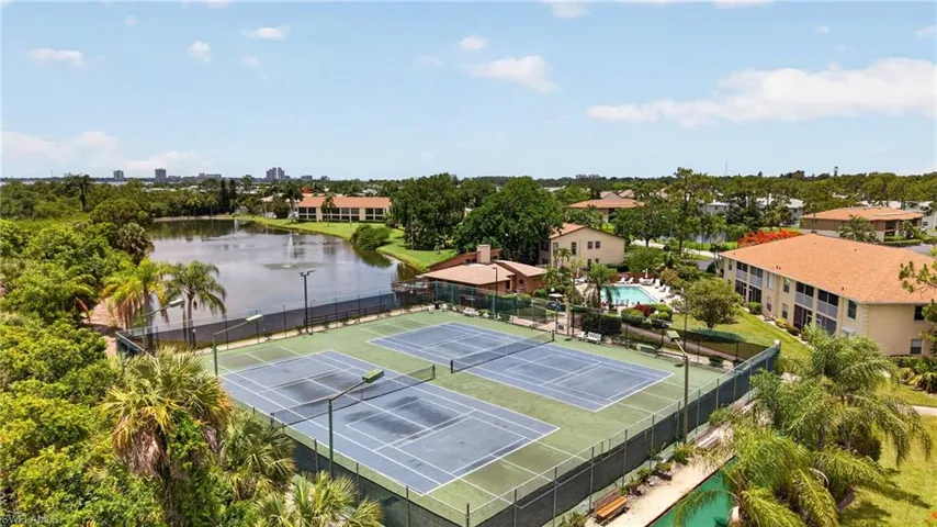Tennis courts featuring blue and green surfaces with surrounding fencing and lighting