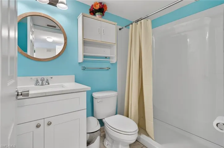 Bathroom with a white vanity featuring a built-in sink, chrome faucet, and storage cabinetry below