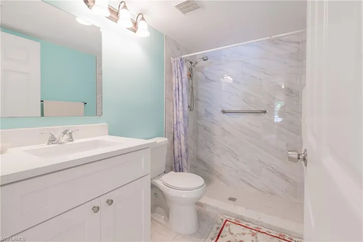 Bathroom featuring a single vanity with white cabinetry, a white countertop, and a rectangular undermount sink