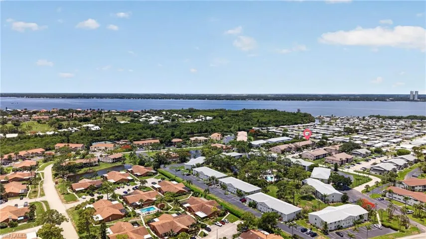 Expansive aerial perspective showcasing a residential community with a large body of water in the background