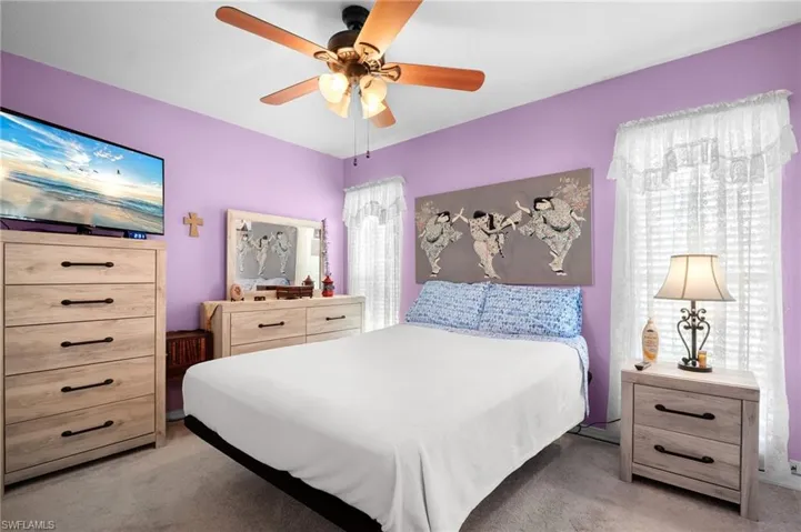 Bedroom with light carpet and a ceiling fan