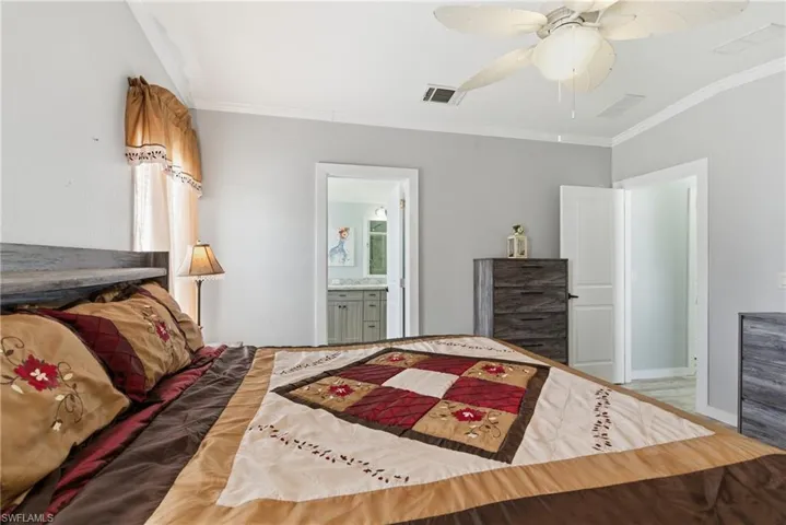 Bedroom featuring ornamental molding, connected bathroom, and ceiling fan