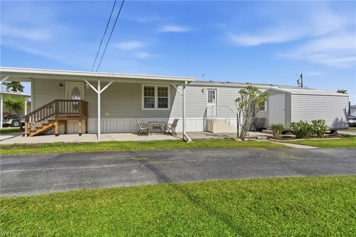 Manufactured / mobile home with a front yard and a porch