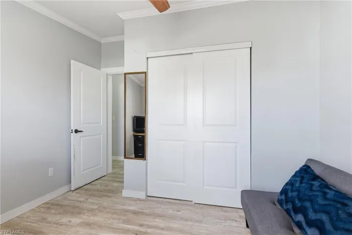Living area with ornamental molding and light wood-style floors