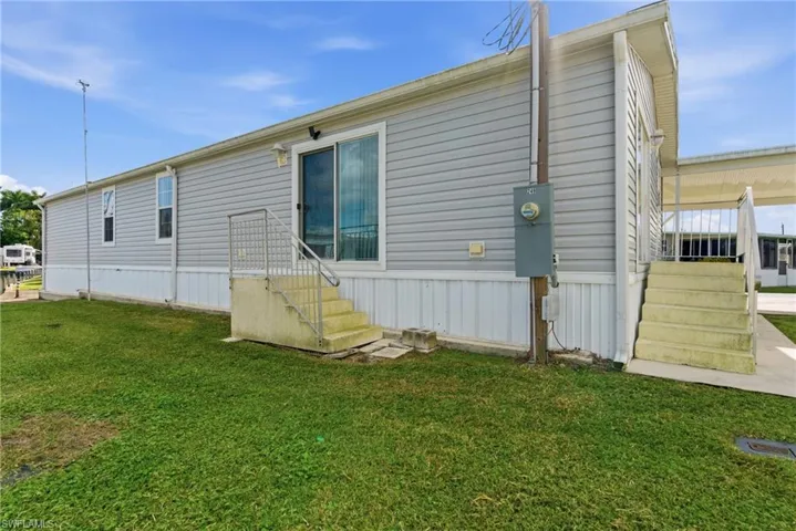 Back of property featuring a lawn