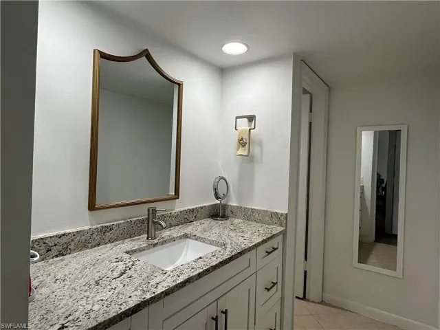 Bathroom featuring vanity, light tile patterned floors, and recessed lighting