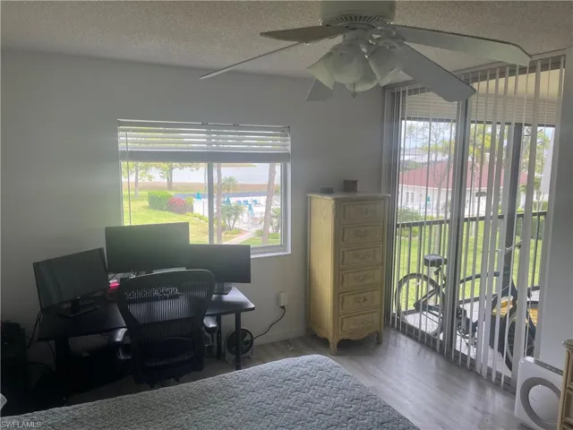 Home office with a textured ceiling, wood finished floors, and a ceiling fan