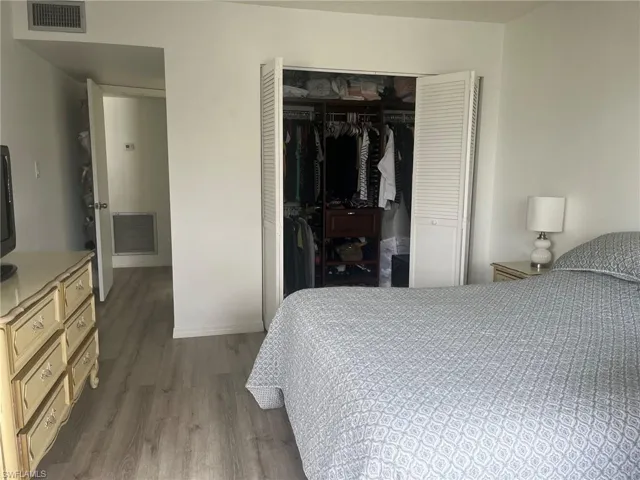 Bedroom featuring dark wood finished floors and a closet