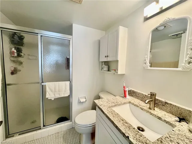 Full bathroom with a stall shower, vanity, and light tile patterned floors