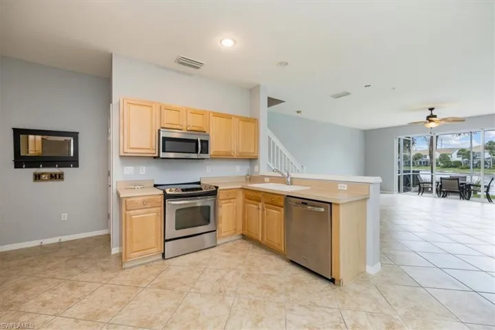 Kitchen with appliances with stainless steel finishes, wood cabinetry.