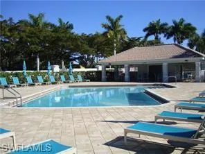 Community pool and spa featuring a covered patio area with fans and bathrooms. Gas grills located just outside the fence