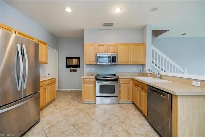 Kitchen featuring stainless appliances with stainless steel finishes, light countertops, wood cabinetry, and recessed lighting
