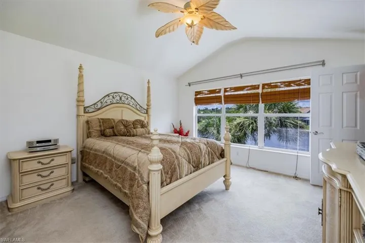 Bedroom featuring lofted ceiling, light carpet, and ceiling fan