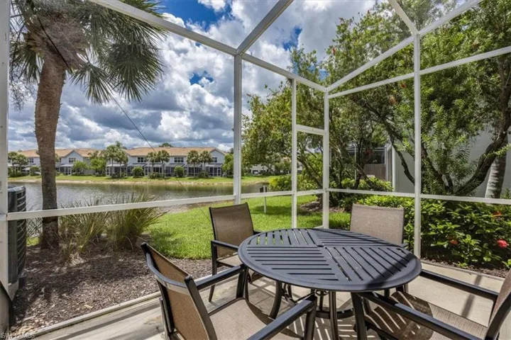Sunroom featuring a water view, outdoor dining space, and a residential view