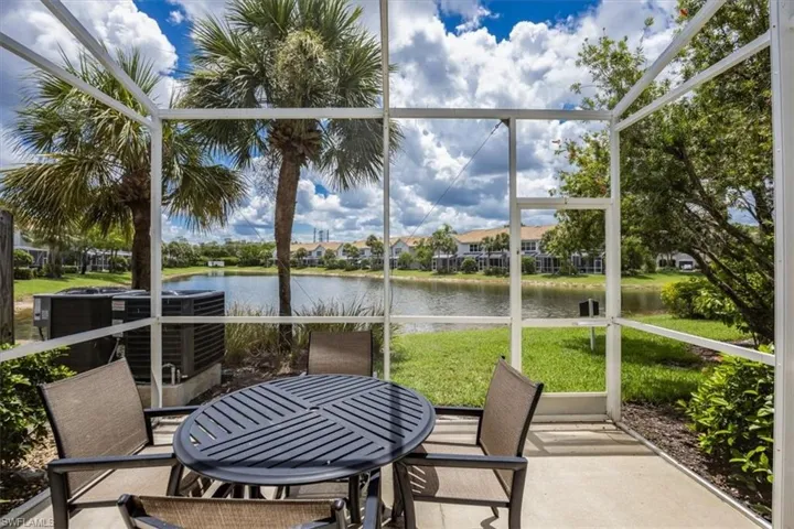 Sunroom featuring a water view, outdoor dining space, and a residential view