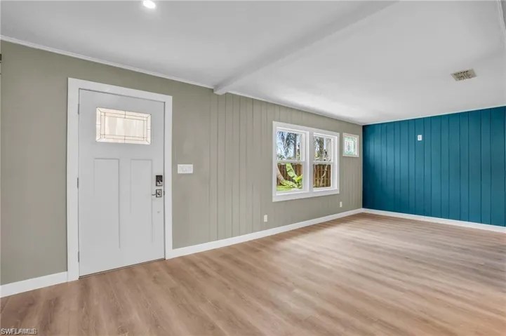 Foyer with visible vents, baseboards, beamed ceiling, and wood finished floors