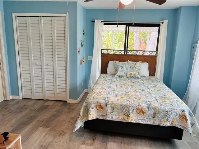 Bedroom featuring a closet, ceiling fan, wood finished floors, and baseboards
