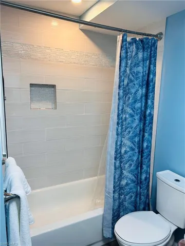 Full bath featuring shower / bath combo and toilet