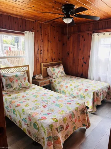 Bedroom with wood walls, wood finished floors, and wood ceiling