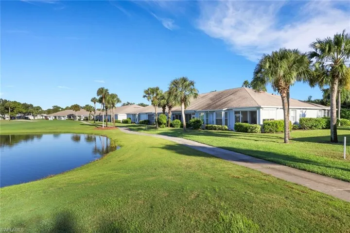 View of home's community with a water view and a lawn