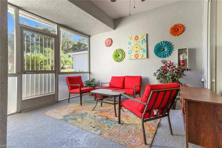 Screened in lanai at front of villa with ceiling fan and access to primary bedroom