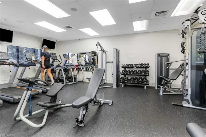 on-site exercise room featuring a paneled ceiling