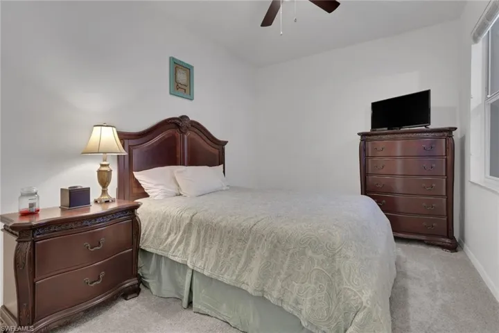 Bedroom with light carpet and a ceiling fan