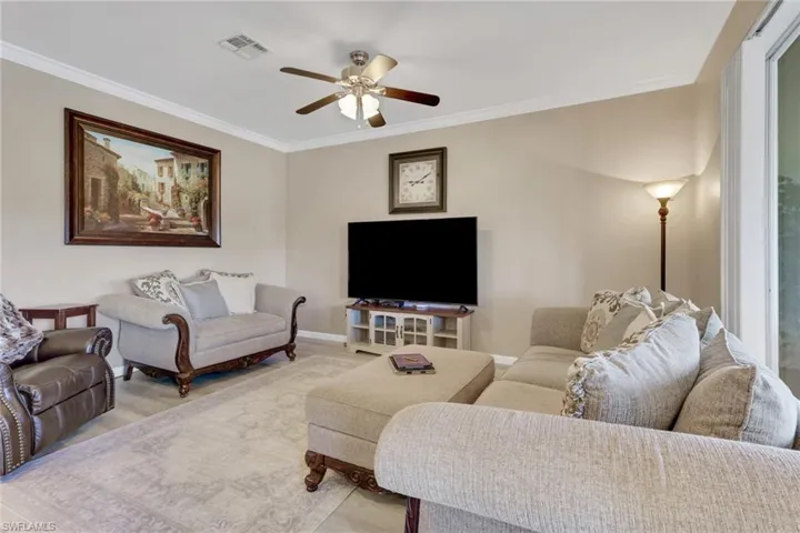 Living area with ornamental molding, ceiling fan, and wood style floors