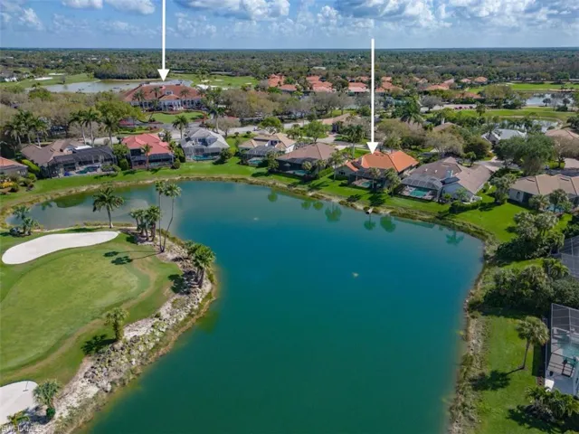 View of property location featuring a nearby body of water, nearby suburban area, and a golf club