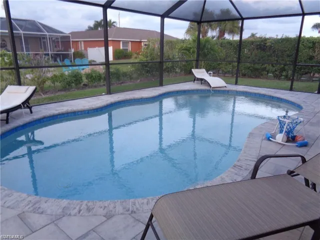 Outdoor pool featuring a sunroom and a lanai
