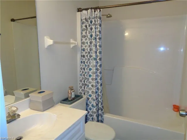 Bathroom with vanity and shower / bathtub combination with curtain