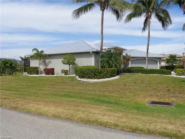 View of property exterior featuring a lawn and stucco siding