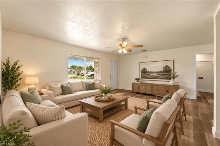 Virtually Staged Spacious living area featuring wood-finish flooring, a ceiling fan, and a large window