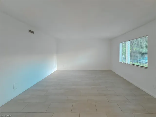 Spare room with baseboards and light tile patterned flooring