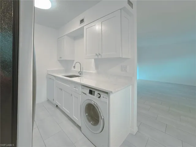Laundry area featuring washer / clothes dryer and light tile patterned floors