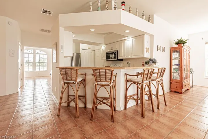 Kitchen featuring plenty of natural light, a breakfast bar area, and light tile patterned flooring